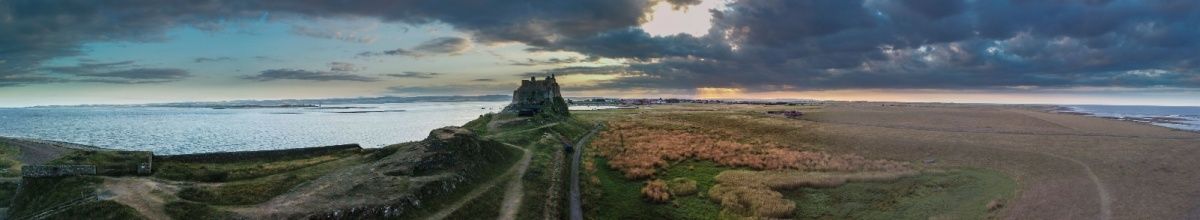 Panorama von Lindisfarne mit dem Kloster in der Mitte bei Dämmerung.