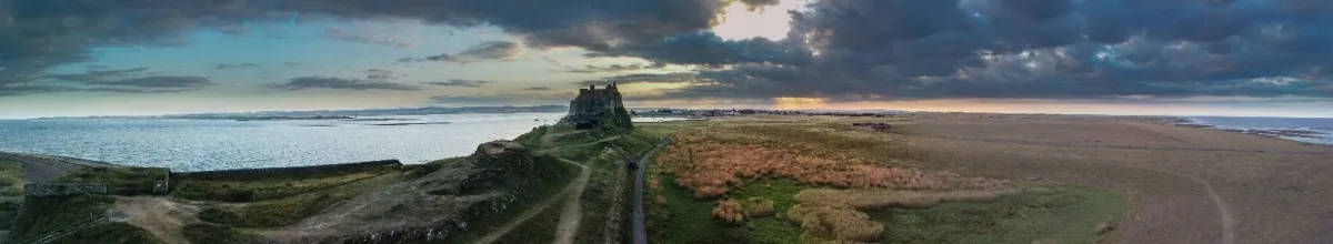 Panorama von Lindisfarne mit dem Kloster in der Mitte bei Dämmerung.