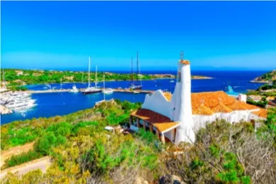 Eine Kirche in Porto Cervo Die Kirche Stella Maris in Porto Cervo bei Tag mit einer weißgetünchten Fassade vor dem tiefblauen Meer.