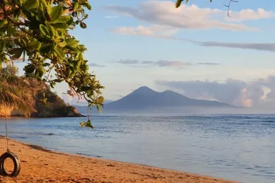 Bitung Orangener Strand mit Blick auf Vulkan in Bitung.