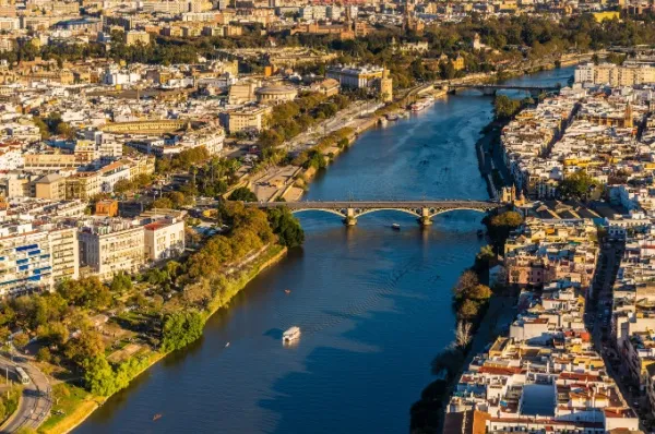 Rundumblick auf die Stadt, mittendrin der Fluss Guadalquivir mit einer Brücke.