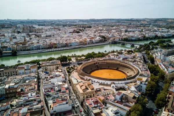 Die Stierkampfarena umgeben von Häusern am Fluss Guadalquivir.