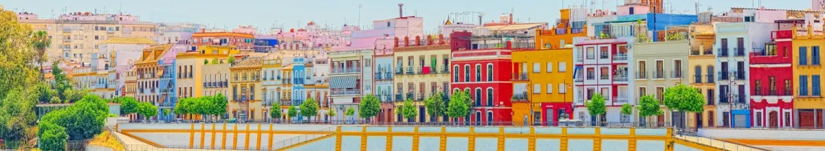 Blick auf Promenade am Fluss mit bunter Häuserreihe.