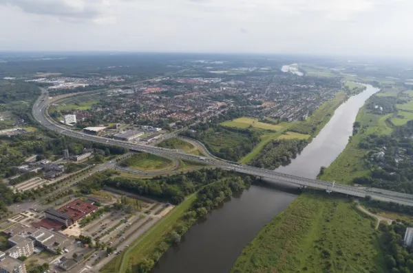 Blick auf Venlo an der Maas mit der Autobahnbrücke im Grünen.
