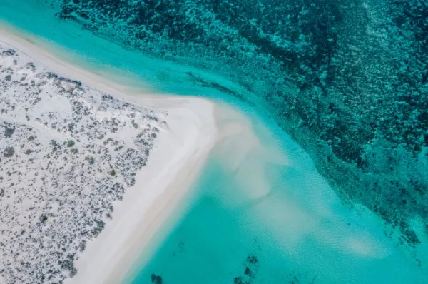 Vogelperspektive auf die Küste von Exmouth mit dem Ningaloo-Riff was unmittelbar am Strand liegt.