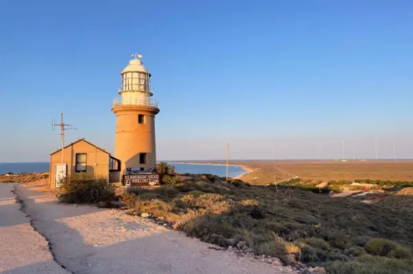 Das Vlamingh Head Lighthouse bei Exmouth während des Sonnenuntergangs mit Ausblick auf das angrenzende Meer.