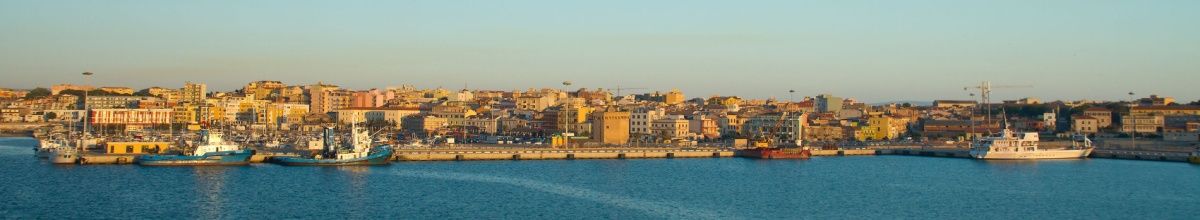 Blick auf die Gebäude der Stadt Porto Torres bei Sonnenuntergang.