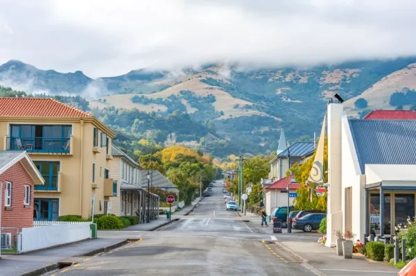 Straße in Akaroa Straße in Akaroa mit bunten Häuserfronten und Bergen im Hintergrund.