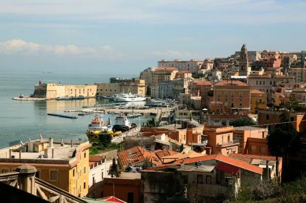 Blick auf den Hafen von Gaeta umgeben von Altstadt-Häusern am Meer.