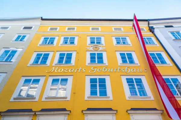 Das Geburtshaus von Mozart Die knallgelbe Fassade des Geburtshauses von Mozart in der Getreidegasse mit einer österreichischen Flagge.