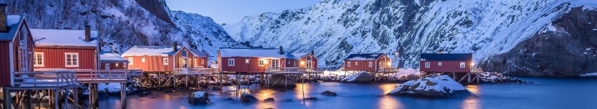 Die Holzhütten von Nusfjord sind von Schnee umgeben.