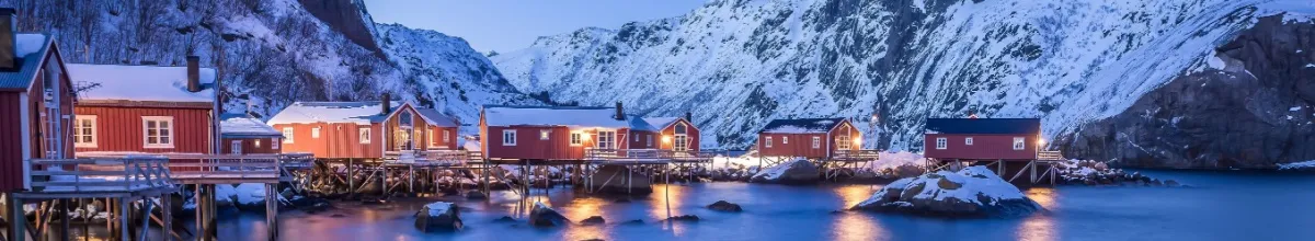 Die Holzhütten von Nusfjord sind von Schnee umgeben.