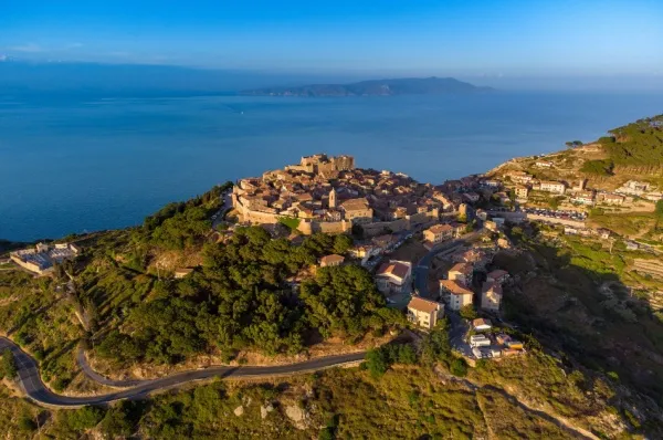Der Stadtteil Giglio Castello liegt erhöht auf einem Berg, umgeben von alten Stadtmauern, im Hintergrund das Meer.