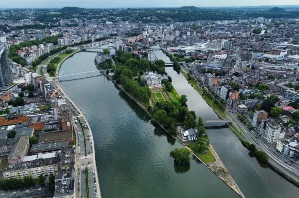 Flusslandschaft umgeben von den Gebäuden der Stadt Lüttich.