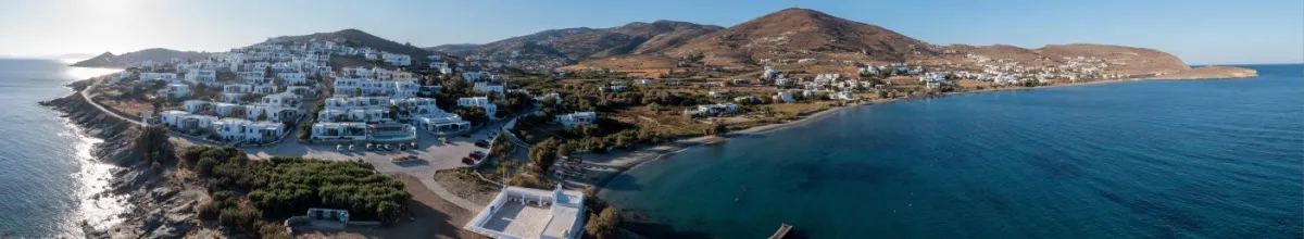 Die weißen Häuser von Tinos-Stadt reihen sich entlang der kargen Küste auf.