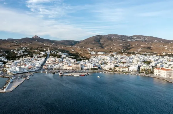 Tinos-Stadt mit weißen Häuserfassaden am Meer bei Tag.