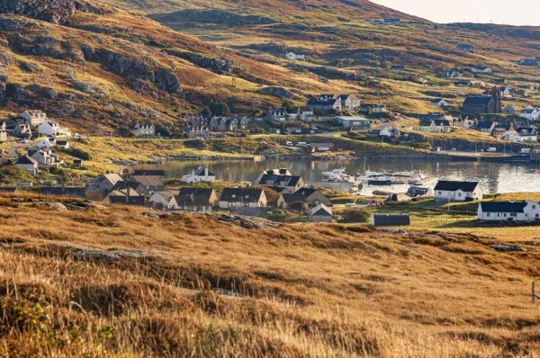 Das Dorf Castlebay auf der schottischen Insel Barre mit weitläufigen Wiesen direkt am Meer.