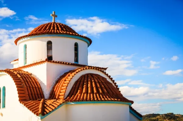 Agios Nikolaos Kirche mit Kirchturm unter blauem Himmel.