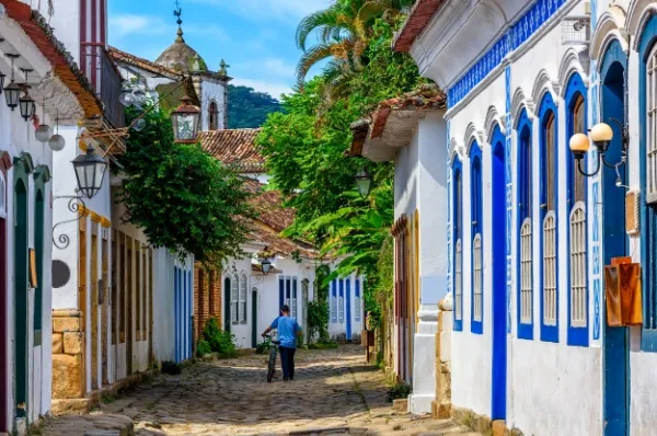Ein Mann schiebt sein Fahrrad durch die kopfsteingepflasterten Gassen der Altstadt von Paraty.