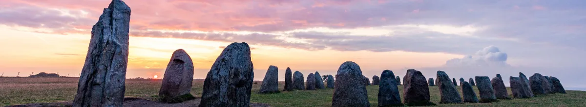 Obelisken aus Stein in einer Reihe, nahe der Stadt Ystad bei Sonnenuntergang.
