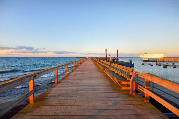Ein Holzsteg am Hafen von Ystad während der Golden Hour.
