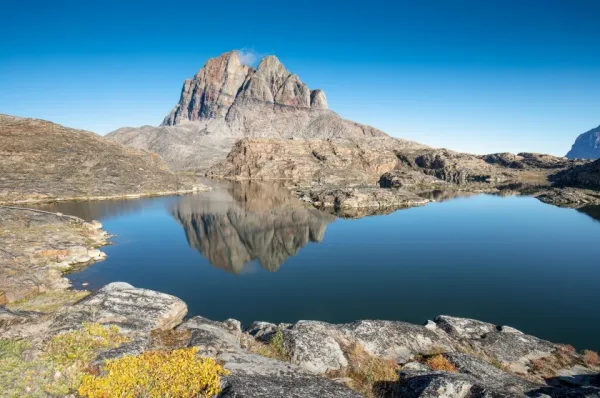 Der Berg Uummannaqs ragt hinter einem blauen See empor.