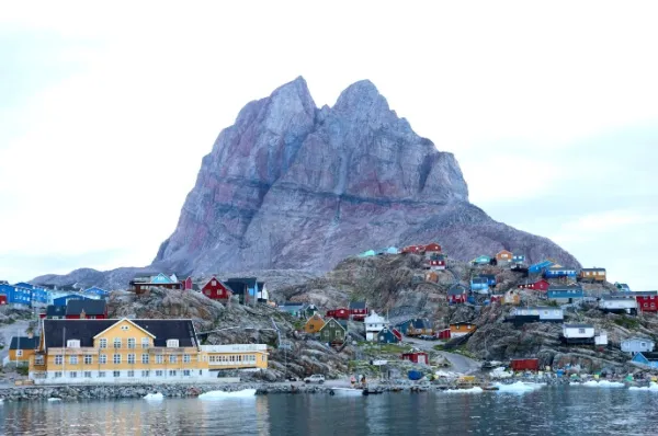 Die Stadt Uummannaq mit ihren bunten Häusern vor dem riesigen Berg in Herzform.