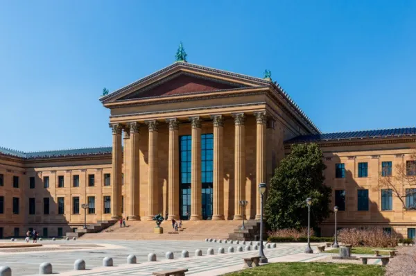 Das Kunstmuseum in Philadelphia hat Säulen und steht imposant bei strahlend blauem Himmel.