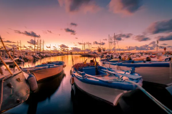 Der Hafen von Vieste bei Sonnenuntergang mit zahlreichen vertauten Sport- und Fischerbooten.