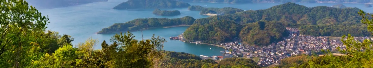 Panoramablick auf die von Bergen umringte Bucht von Maizuru.
