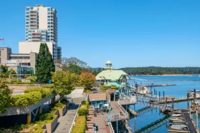 Holz-Anlegestellen für Boote in Nanaimo, im Hintergrund ein Hochhaus.