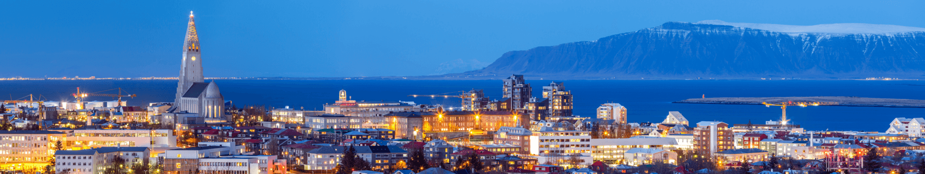 Über den Dächern von Reykjavik sieht man das Leuchten in den Fenstern.