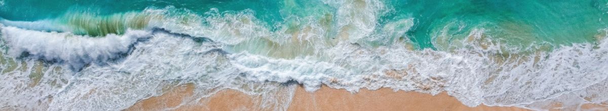 Wellen brechen am Strand von Ambodifototra aus der Vogelperspektive.