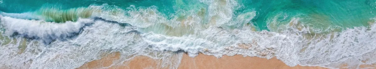 Wellen brechen am Strand von Ambodifototra aus der Vogelperspektive.