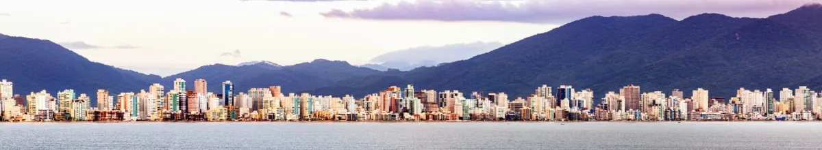 Die Skyline von Porto Belo mit Strand im Vorder- und Bergen im Hintergrund.