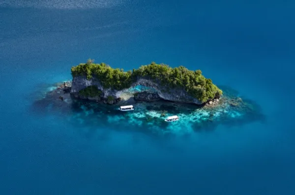 Eine kleine unbewohnte, aber mir Regenwald bewachsene Insel mit zwei kleinen Booten.