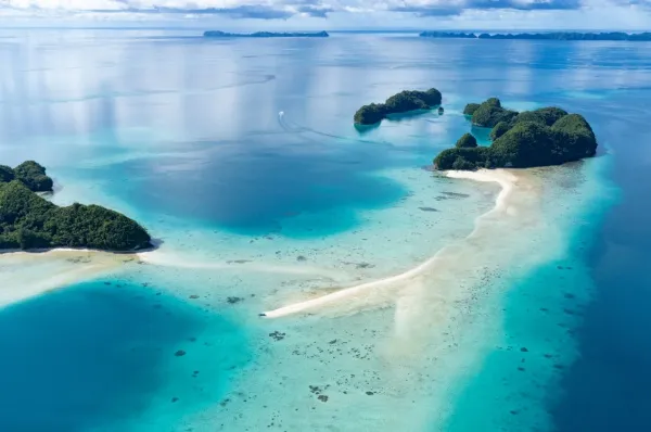 Zwei kleine Inselformationen mit einer Sanddüne und tief blauem Wasser.