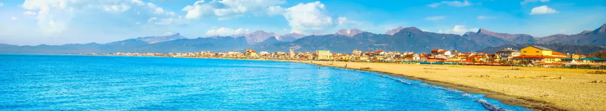 Die Küste von Viareggio Der endlose Sandstrand an der Küste Viareggios bei Sonnenschein, mit dem angrenzenden Mittelmeer.
