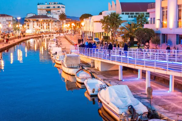 Ein Kanal in Viareggio Ein malerischer Kanal durch Viareggio bei Nacht, warm beleuchtet von den Lichtern der angrenzenden Häuser mit kleinen Booten und Anlegern.