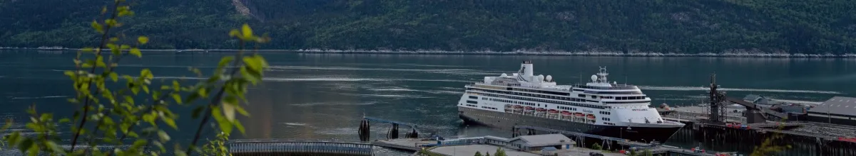 Die Volendam legt am Hafen in Skagway an, im Hintergrund die Berge.