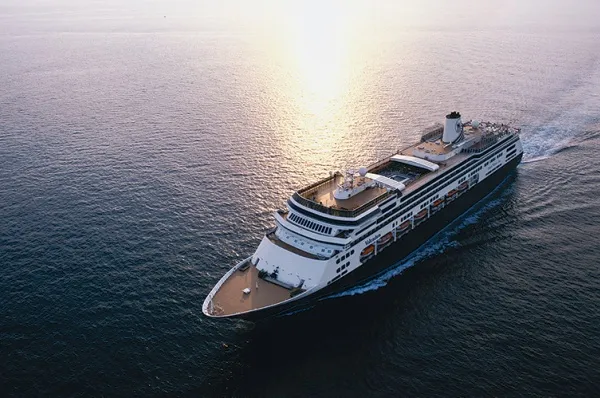 Volendam Vogelperspektive auf die Volendam, die bei Sonnenuntergang über das Meer fährt.