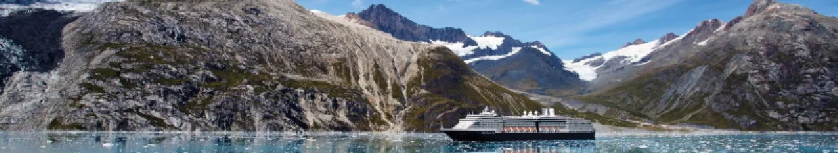 Seitenansicht der Westerdam auf dem Polarmeer, im Hintergrund ein schroffes Bergpanorama.