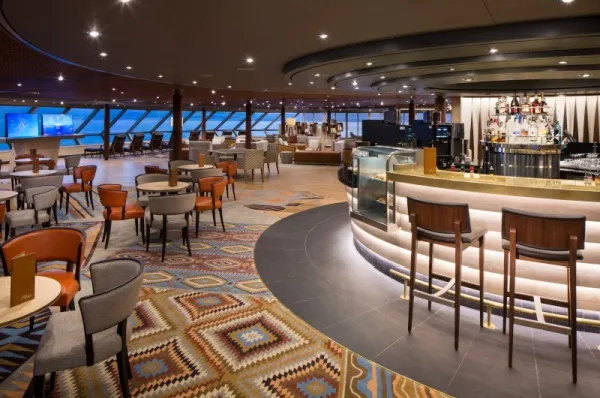 Explorations Cafe Bei Nacht erleuchtetes Restaurant/Cafe an Bord der Westerdam mit Bar und Tischen.
