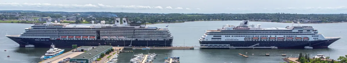 Zwei Schiffe der Holland America Line liegen vor Anker.