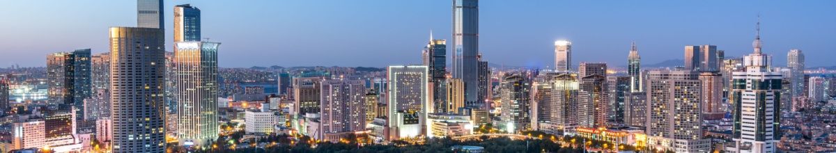 Wolkenkratzer-Skyline am Abend in Dalian.