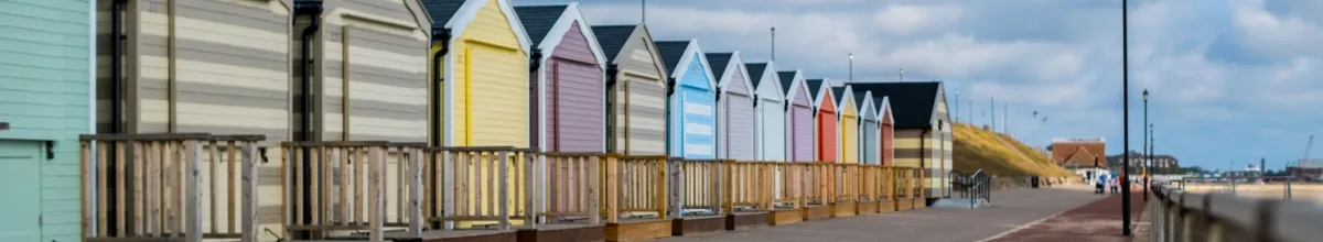 Kleine, bunte Strandhäuser reihen sich auf.