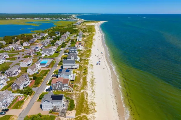 Der weiße Sandstrand von Yarmouth mit fein aufgereihten Villen und türkisem Meer.