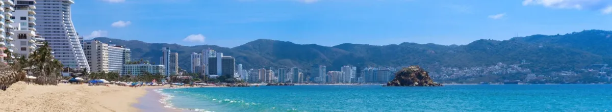 Bucht von Acapulco mit hellem Sandstrand, von Hochhäusern umgeben.