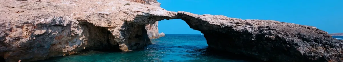 Eine natürliche Felsbrücke mit einem Loch direkt im Meer liegend.