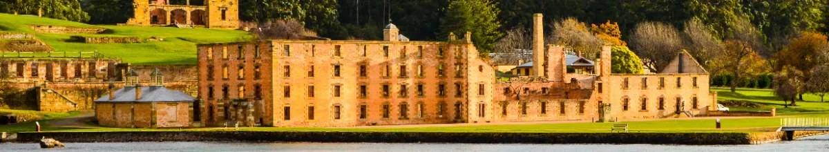 Eine Gebäuderuine an der Küste Die Ruine eines alten Gefängnisses an der Küste von Port Arthur bei Sonnenschein.